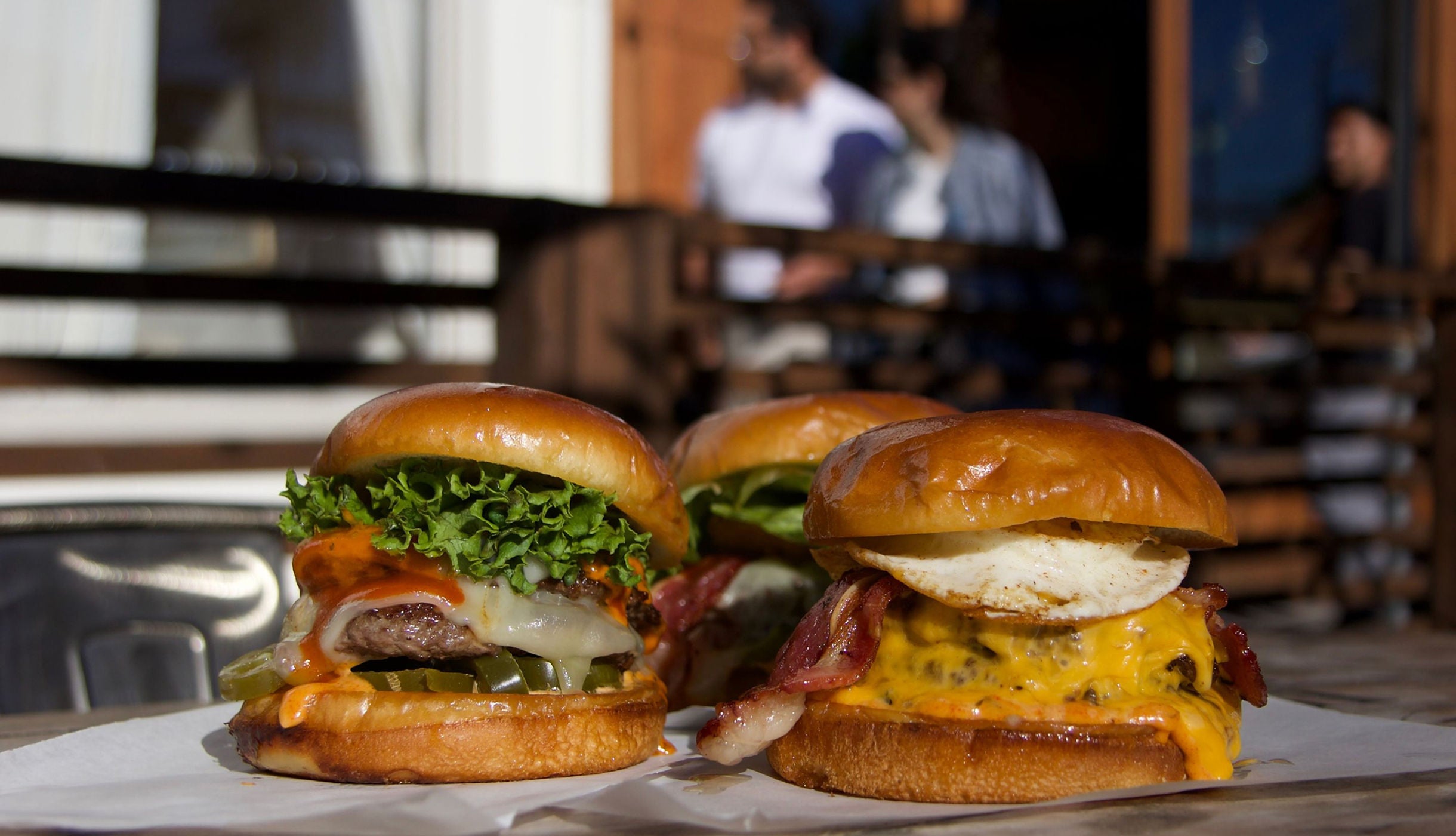 Two Urban Skillet burgers on a table inside the restaurant