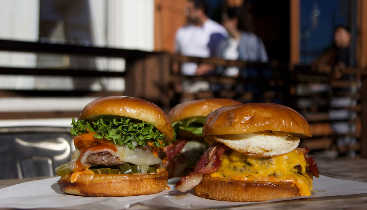 Urban Skillet burgers served together at a restaurant table